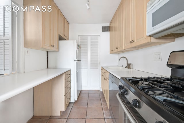 kitchen featuring visible vents, white microwave, stainless steel range with gas cooktop, a sink, and dishwasher