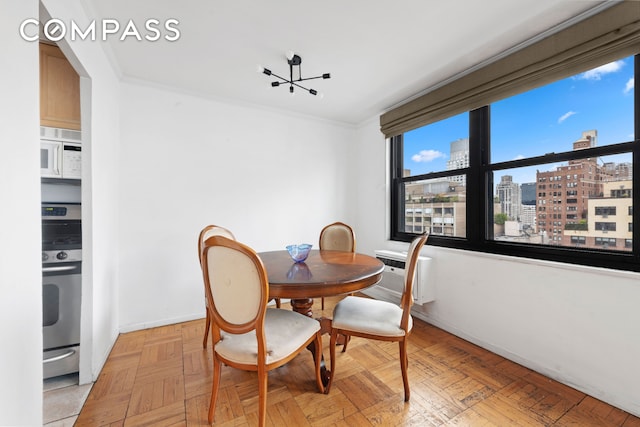 dining area with baseboards, a city view, a wall unit AC, and ornamental molding