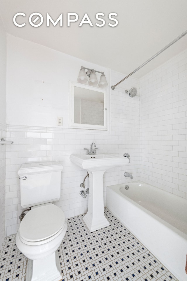 full bathroom with toilet, tile walls, bathing tub / shower combination, and tile patterned flooring