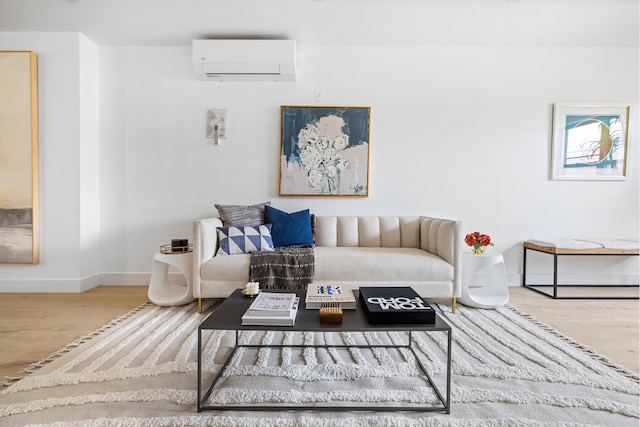 living area featuring an AC wall unit, baseboards, and wood finished floors