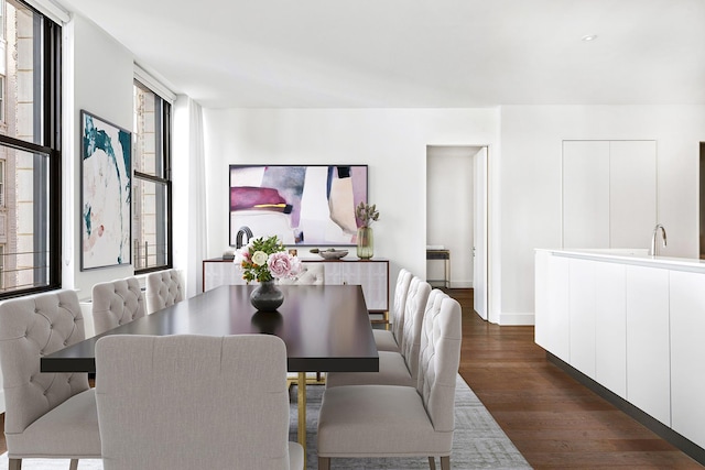 dining area featuring dark wood-type flooring and baseboards