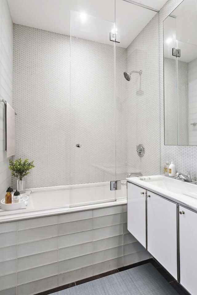 full bathroom featuring an enclosed shower, tile walls, a bath, and vanity