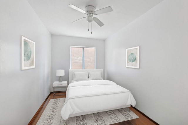 bedroom with dark wood-style flooring, baseboards, and a ceiling fan