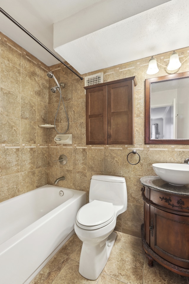 full bathroom featuring toilet, tile walls, bathtub / shower combination, and vanity