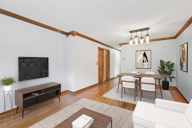 living room featuring baseboards, ornamental molding, and wood finished floors