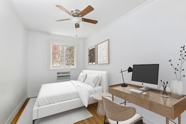 bedroom with crown molding, a ceiling fan, baseboards, a wall unit AC, and wood finished floors