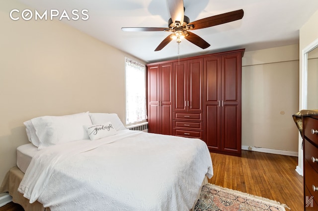 bedroom featuring baseboards, ceiling fan, and dark wood-style floors