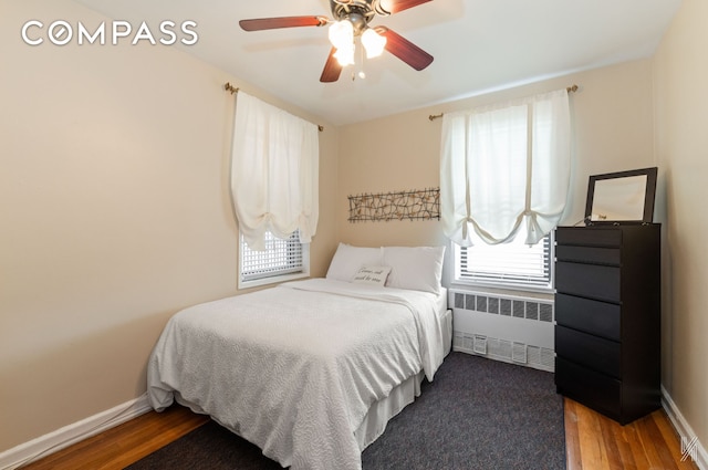 bedroom featuring ceiling fan, radiator, baseboards, and wood finished floors