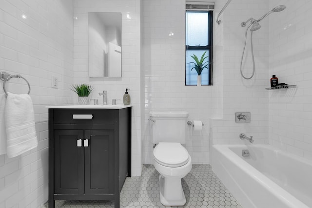 full bath with tile patterned flooring, vanity, toilet, tile walls, and shower / bathing tub combination