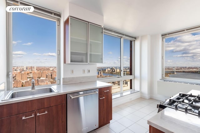 kitchen featuring dishwasher, a sink, light countertops, and light tile patterned flooring