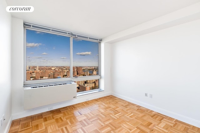 unfurnished room featuring radiator heating unit and baseboards