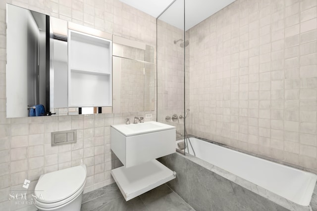 full bathroom featuring tile patterned flooring, vanity, toilet, tile walls, and tiled shower / bath combo
