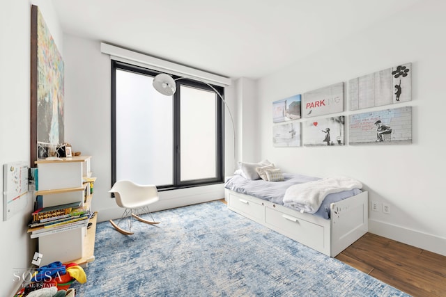 bedroom with baseboards and wood finished floors