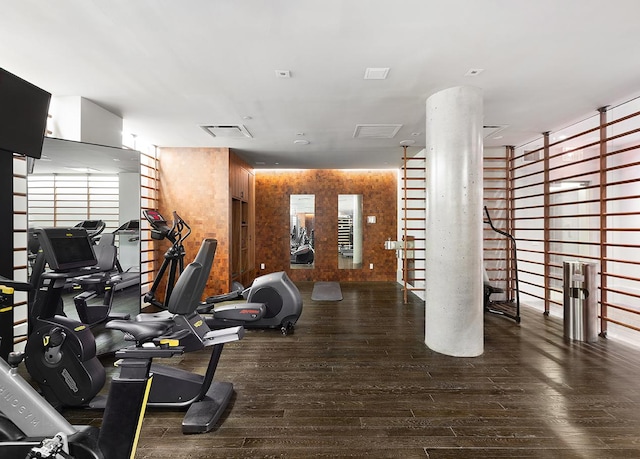 exercise room with wood-type flooring and visible vents