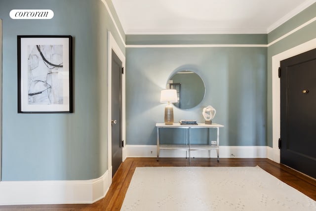 entrance foyer featuring baseboards, ornamental molding, and wood finished floors