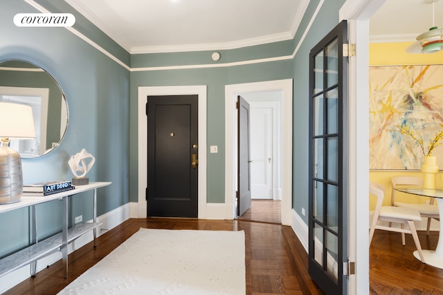 foyer with baseboards, ornamental molding, wood finished floors, and visible vents