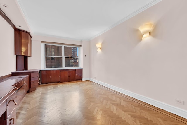 interior space featuring baseboards, ornamental molding, and brown cabinetry