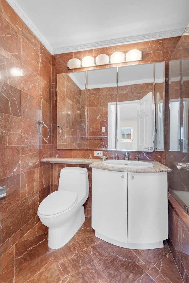 bathroom with vanity, marble finish floor, toilet, and tile walls