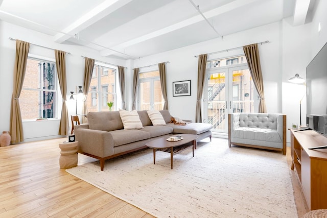 living area featuring light wood-style floors, french doors, and beamed ceiling