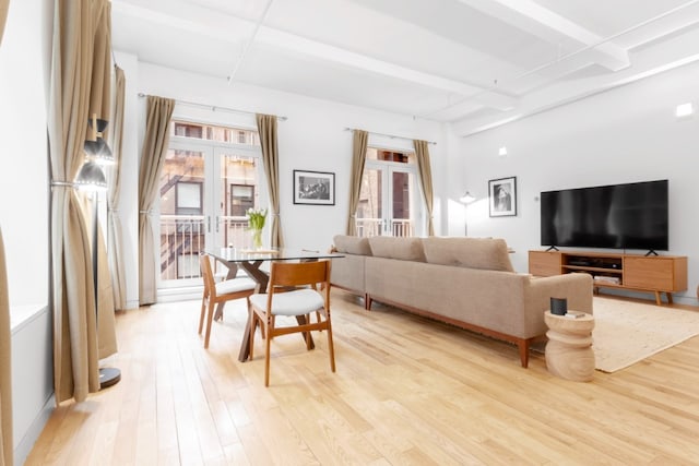 living room with light wood-style floors, french doors, and beam ceiling