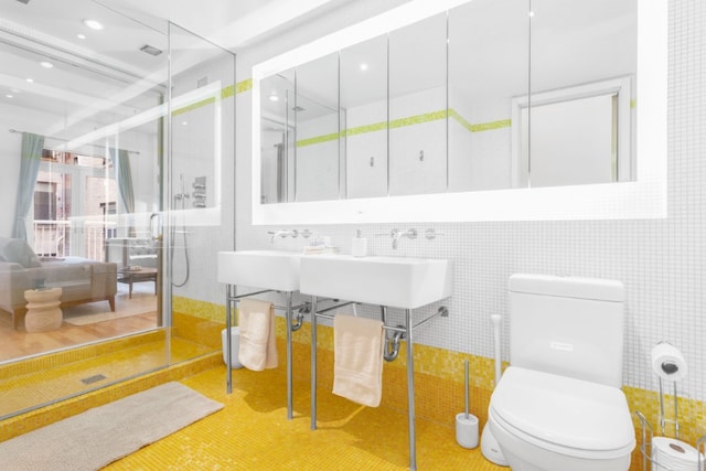 full bath with recessed lighting, tile walls, toilet, and a shower stall