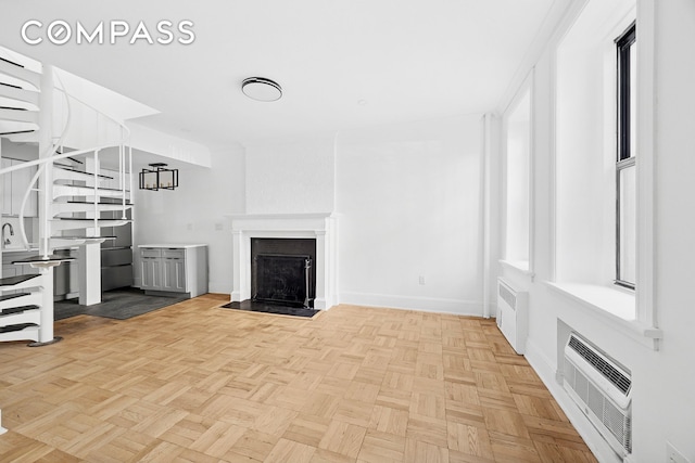 134 W 80th Street Parlor, New York City, NY 10024 - unfurnished living room featuring a fireplace with flush hearth, an AC wall unit, baseboards, and radiator heating unit