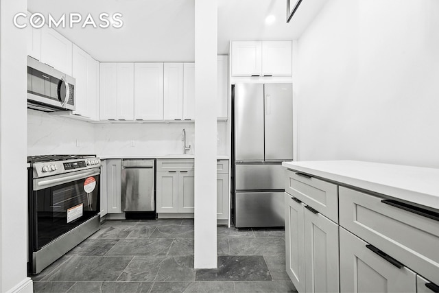 134 W 80th Street Parlor, New York City, NY 10024 - kitchen with stainless steel appliances, a sink, light countertops, and white cabinets