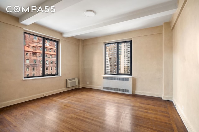 50 Park Ave Unit 15B, New York City, NY 10016 - empty room featuring radiator, beam ceiling, wood finished floors, and healthy amount of natural light