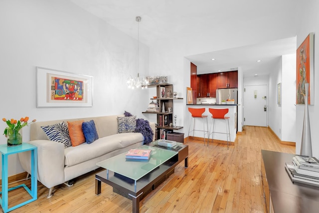 living area featuring baseboards, recessed lighting, and light wood-style flooring