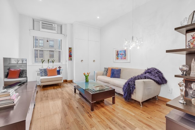 living room with light wood-style floors, recessed lighting, and a notable chandelier