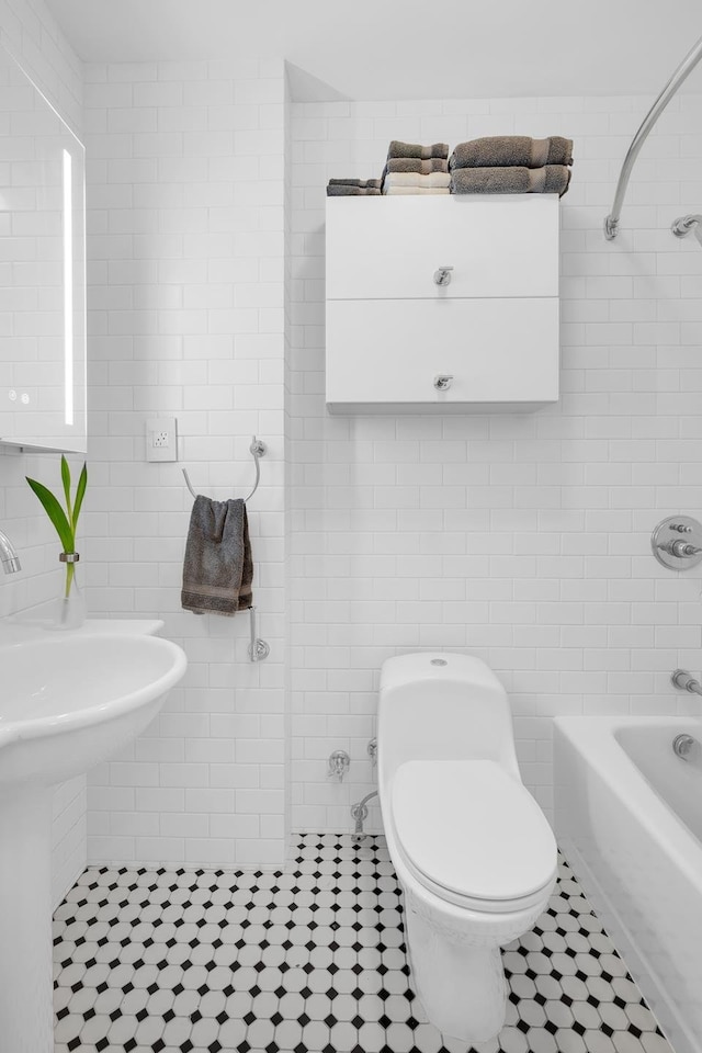 bathroom with shower / tub combination, tile patterned floors, toilet, and tile walls