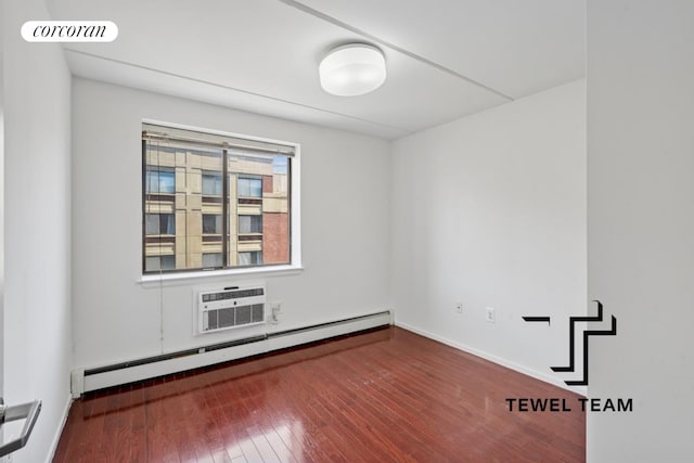 empty room featuring visible vents, a baseboard radiator, a wall mounted AC, and hardwood / wood-style flooring