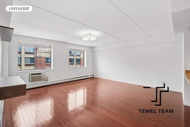 unfurnished living room with visible vents, wood finished floors, baseboards, a wall mounted AC, and a baseboard radiator