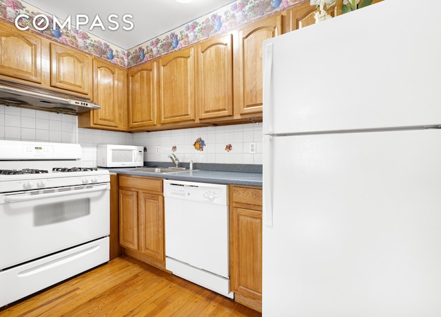 41-26 71st St Unit 1A, New York City, NY 11377 - kitchen featuring white appliances, under cabinet range hood, a sink, decorative backsplash, and dark countertops