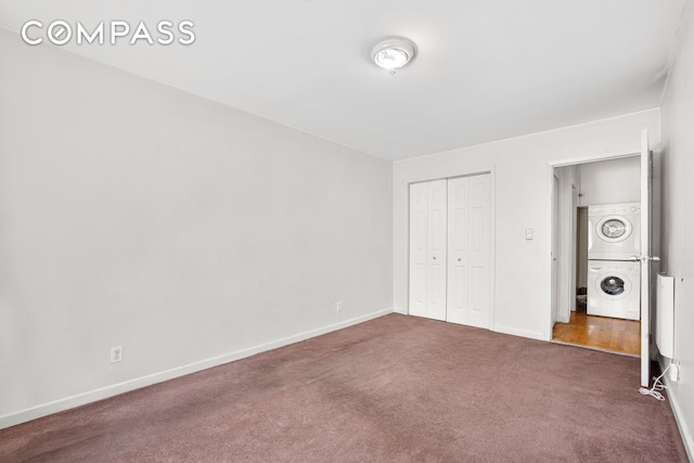 41-26 71st St Unit 1A, New York City, NY 11377 - unfurnished bedroom featuring stacked washer / dryer, carpet floors, a closet, and baseboards