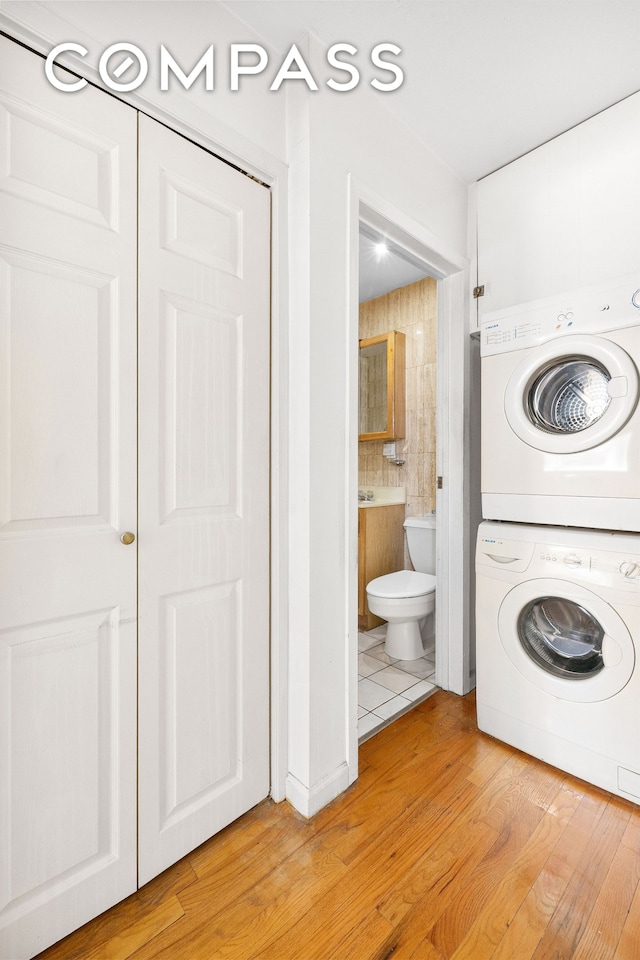 41-26 71st St Unit 1A, New York City, NY 11377 - laundry area with stacked washer and clothes dryer and light wood-style floors
