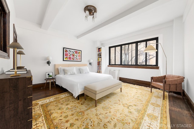 bedroom with radiator heating unit, baseboards, beam ceiling, and wood finished floors