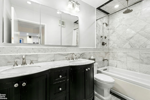 bathroom featuring a sink, bathing tub / shower combination, toilet, and double vanity