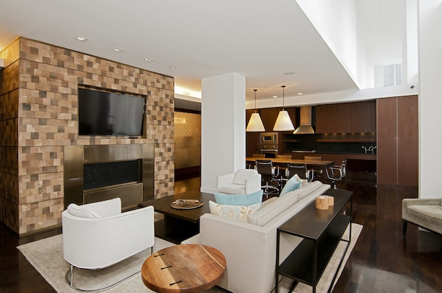 living area featuring recessed lighting, dark wood finished floors, and a fireplace