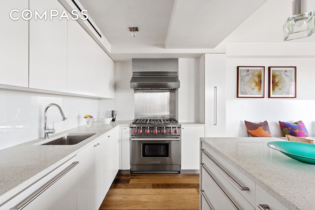 45 E End Ave Unit 6/7B, New York City, NY 10028 - kitchen featuring designer stove, extractor fan, a sink, white cabinetry, and dark wood-style floors
