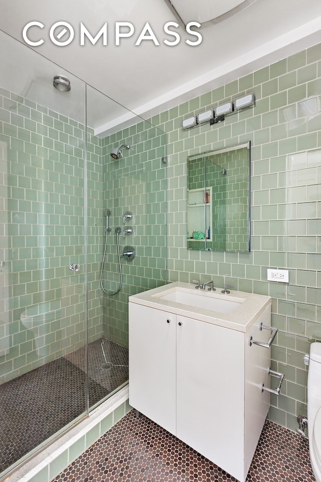 45 E End Ave Unit 6/7B, New York City, NY 10028 - bathroom featuring tile patterned floors, a stall shower, toilet, vanity, and tile walls