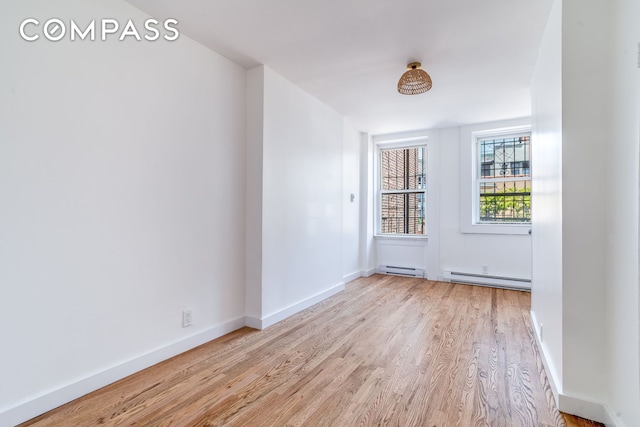 217 E 5th St Unit 6, New York City, NY 10003 - spare room featuring light wood-style floors, baseboard heating, and baseboards
