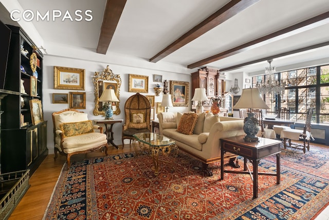 living room featuring wood finished floors, a notable chandelier, and beamed ceiling