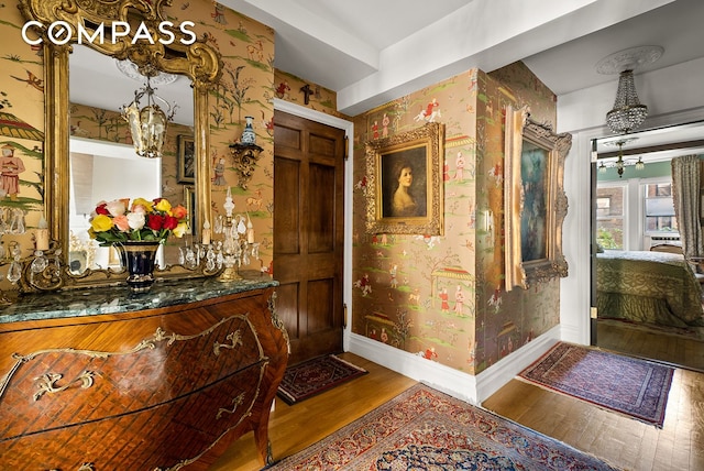 interior space with an inviting chandelier, baseboards, and wallpapered walls