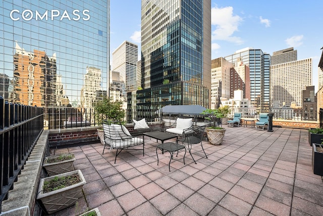 view of patio / terrace featuring fence and a view of city
