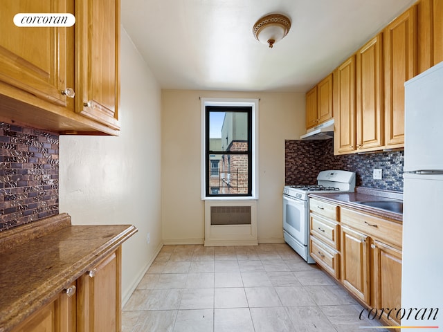 kitchen featuring decorative backsplash, marble finish floor, white appliances, baseboards, and under cabinet range hood