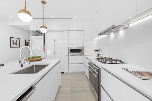 224 N 6th Street Parlour, New York City, NY 11211 - kitchen with stacked washer / drying machine, a sink, modern cabinets, stainless steel appliances, and recessed lighting
