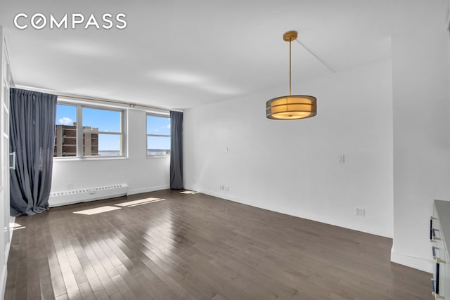 75 Henry St Unit 29J, New York City, NY 11201 - empty room featuring baseboard heating, dark wood finished floors, and baseboards
