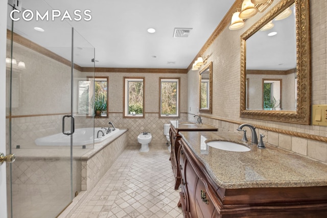 bathroom featuring a healthy amount of sunlight, tile walls, a sink, and visible vents