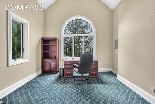 home office featuring baseboards, vaulted ceiling, and dark colored carpet